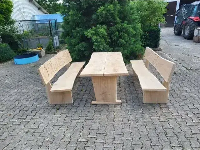 Gartengarnitur aus hellem Holz mit Tisch und zwei Bänken