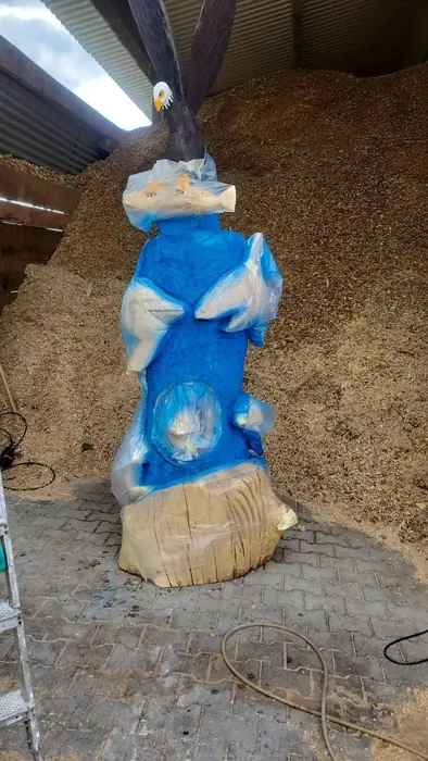 Holzsäule während des Bemalens mit blauer Grundfarbe